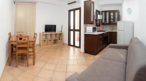 a kitchen and living room with a couch and a table at Le Amiche in Marina di Ragusa +17 photos