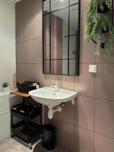 un bagno con un lavandino bianco e uno specchio di RG Aisa Apartment a Pärnu Altre 13 foto