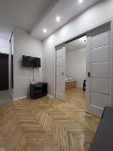 a living room with a sliding door and a television at Centrum Lipowa 16 Apartamenty LUNA Bialystok in Białystok +2 photos