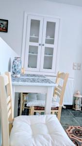 a dining room table with chairs and a white table at Stellinas House 2 in Andros +13 photos
