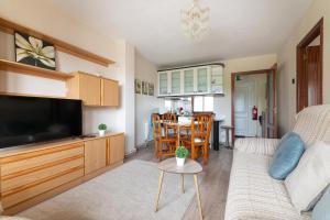 a living room with a couch and a tv and a table at Mi casita del norte a 150 m de la playa in Mogro