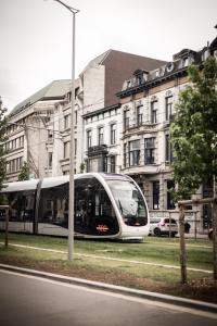 a train on a street in front of a building at La Tour in Liège +33 photos