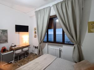 a bedroom with a bed and a desk and a window at Loft Giudina in Taormina