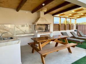 a kitchen with a wooden table and a stove at Aristea Seaside Retreat with Private Pool in Kalamaki Heraklion