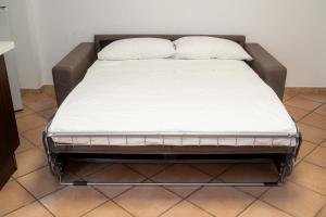 a bed in a room with a white mattress at Le Amiche in Marina di Ragusa