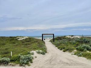 a dirt road leading to the beach at Beachgate Condo Suites and Hotel 121 condo in Port Aransas +6 photos