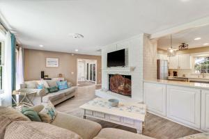a living room with a couch and a fireplace at 1 Block to Ocean Fun in Hilton Head Island