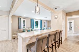 a kitchen and living room with a bar with chairs at 1 Block to Ocean Fun in Hilton Head Island