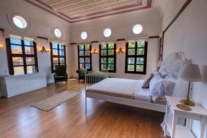 a large bedroom with a large bed and windows at Konak1927 in Edremit