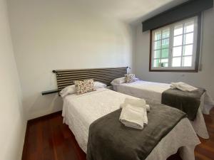 a room with two beds and a window at A un Paso in Caldas de Reis