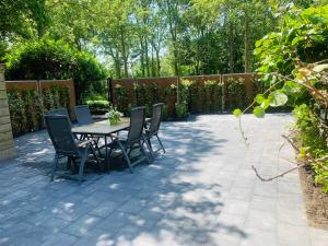 a patio with a table and chairs and a fence at Grijpskerkseweg 3 voorhuis in Oostkapelle