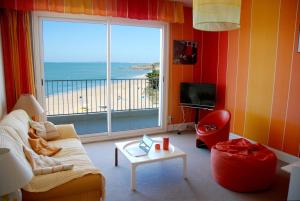 a living room with a couch and a large window at Le Vintage By Tranquil at Home in Pornichet +13 photos
