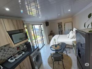 a hotel room with a bed and a kitchen with a table at Stylish Studio in Tableview Stay in Cape Town