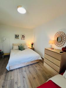 a bedroom with a white bed and a wooden floor at Modern Loft Basel Airport ArtBasel in Saint-Louis