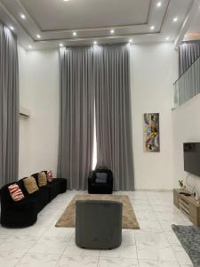 a living room with a couch and a tv at The Residence in Kwabenya