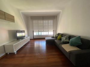 a living room with a couch and a flat screen tv at A un Paso in Caldas de Reis