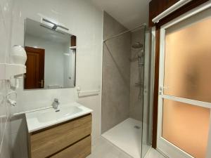 a bathroom with a sink and a shower and a mirror at A un Paso in Caldas de Reis +61 photos
