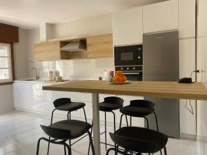 a kitchen with a counter with four stools in it at A un Paso in Caldas de Reis
