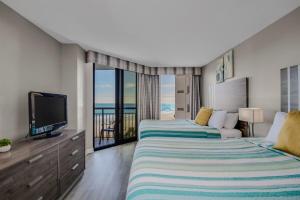een slaapkamer met twee bedden en een flatscreen-tv bij Winter Rates! Calming Oceanfront Suite, Dogs OK! 410 in Myrtle Beach +42 foto's