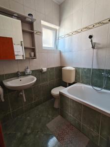 ein Badezimmer mit Badewanne, Toilette und Waschbecken in der Unterkunft Apartments Miljas in Cavtat + 23 Fotos
