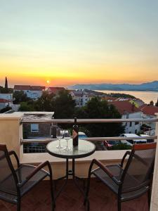 eine Flasche Wein auf einem Tisch auf einem Balkon in der Unterkunft Apartments Miljas in Cavtat