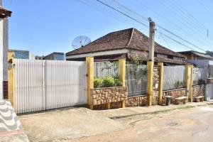 a house with a white fence and a gate at Pousada Colonial in Cachoeiro de Itapemirim
