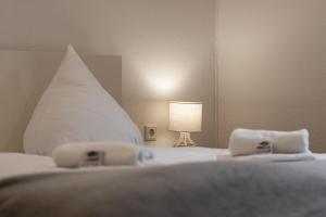 a bedroom with a bed with a white pillow and a lamp at Ferienwohnung Pellwormer Küstenkind in Pellworm