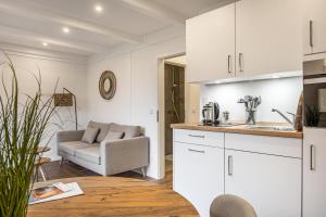 a kitchen and living room with a couch and a table at Ferienwohnung Pellwormer Küstenkind in Pellworm +13 photos