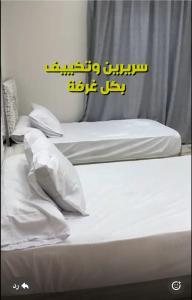 two beds with white sheets and pillows in a room at شقه مفروشه in Cairo
