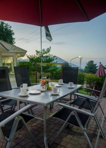 une table avec des chaises et un parasol sur une terrasse dans l'établissement Chinar Resort By Grand Unicorn, à Bhurban