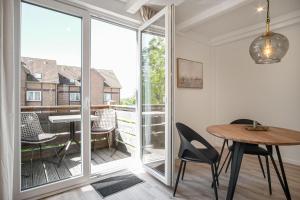 a room with a table and chairs and a balcony at Ferienwohnung Nordseeheimat Pellworm in Pellworm