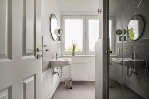 a bathroom with two sinks and two mirrors at Ferienwohnung Deichblick Quartier Pellworm in Pellworm
