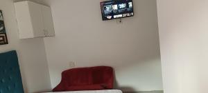 a red chair in a room with a tv on a wall at PEACEFUL SLEEP lodge in Goodwood