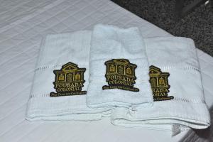 two towels sitting on top of a bed at Pousada Colonial in Cachoeiro de Itapemirim +6 photos