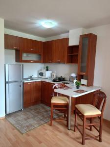 een keuken met houten kasten en een tafel en stoelen bij Mountain Paradise 1 - 2 Bedroom - Large apartment in Bansko