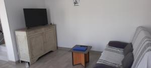 a living room with a tv on top of a dresser at Le chant des oiseaux in Pouant