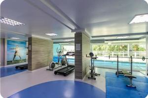 una sala de fitness con piscina y gimnasio en Prédio Central, en Curitiba