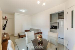 ein Wohnzimmer mit einem Glastisch und Stühlen in der Unterkunft Belo apartamento a menos de 2 min do mar VJG0102 in Cururupe + 5 Fotos