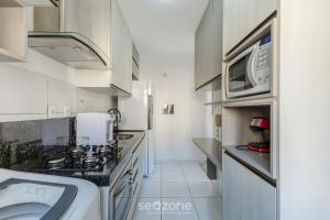 eine kleine Küche mit Spüle und Mikrowelle in der Unterkunft Belo apartamento a menos de 2 min do mar VJG0102 in Cururupe
