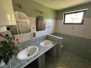 a bathroom with two sinks and a window at Chata Lipa in Bešeňová +10 photos