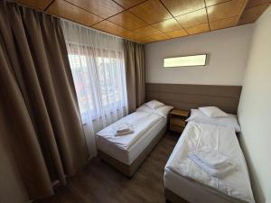 a small room with two beds and a window at Chata Lipa in Bešeňová