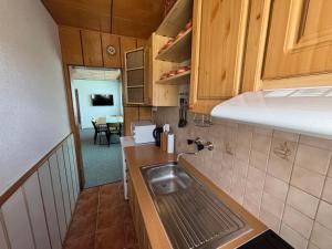a small kitchen with a sink and a table at Chata Lipa in Bešeňová