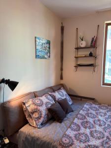 a bedroom with a couch with pillows on it at Cozy studio in Sunny beach in Sunny Beach