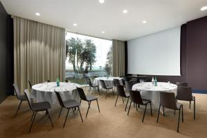 una sala de conferencias con mesas, sillas y una pantalla en Radisson Blu Hotel Nice, en Niza 37 fotos más
