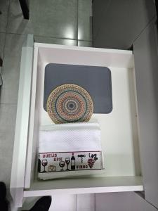 an open refrigerator with towels and a plate in it at Apartamento inteiro, ar-condicionado e vaga de garagem in Paranaguá +12 photos
