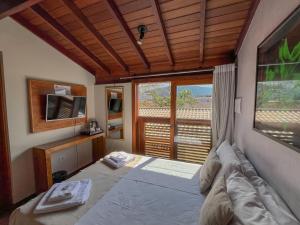 a bedroom with a bed and a large window at Casa Melville Hospedagem - Sua Casa de Alto Padrão no Coração de Ubatuba! in Ubatuba +71 photos
