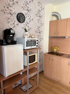a kitchen with a microwave oven on a shelf at Cozy studio in Sunny beach in Sunny Beach +5 photos