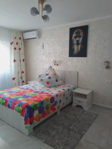 a bedroom with a bed with a colorful comforter at Apartament IRI Băile Herculane in Băile Herculane