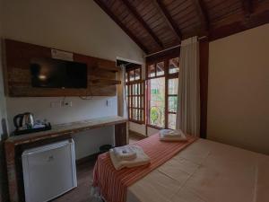 a bedroom with a bed with two towels on it at Casa Melville Hospedagem - Sua Casa de Alto Padrão no Coração de Ubatuba! in Ubatuba
