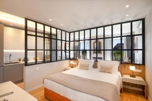 a bedroom with a large bed and large windows at The Elite Corfu Luxury Apartment in Corfu